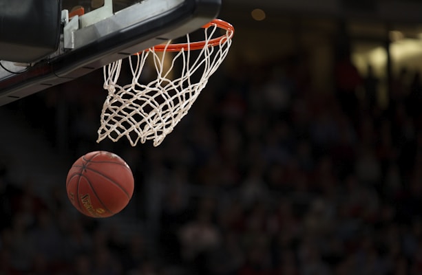 NBA篮球比赛现场，球员身穿球衣在球场上激烈对抗扣篮瞬间