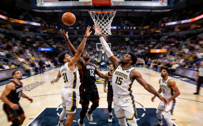 NBA比赛现场，球员在篮下争抢篮板球